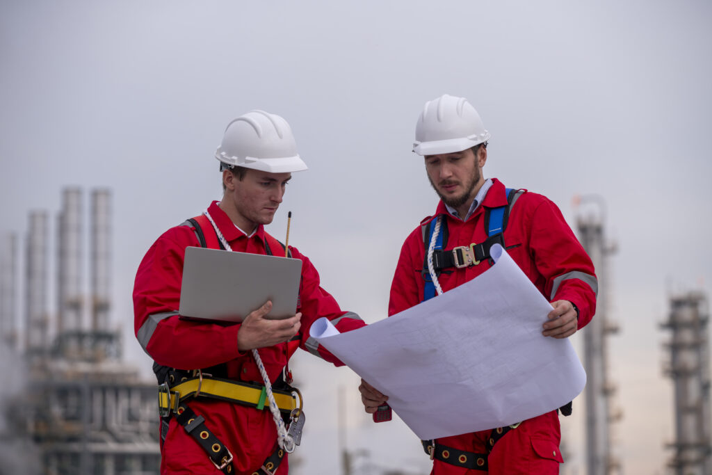 Engineers reviewing blueprints in an industrial plant