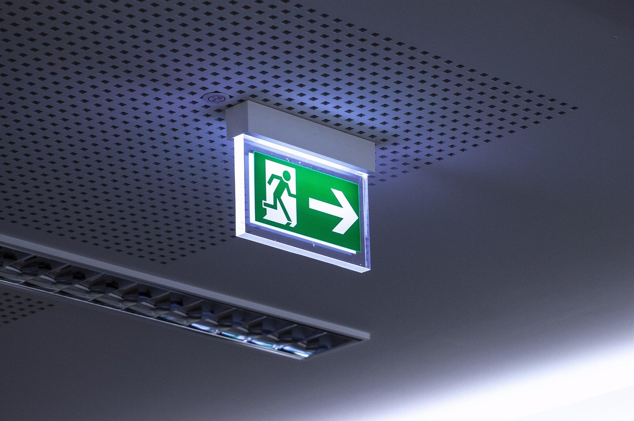 Illuminated emergency exit sign on a ceiling